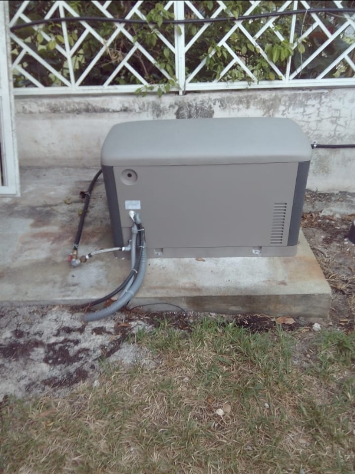 Finished standby generator on a concrete pad outside, connections complete
