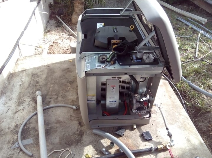Standby generator with cover open, engine and battery exposed for service