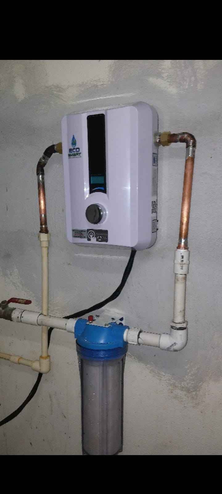Wall-mounted EcoSmart tankless water heater wired and plumbed in