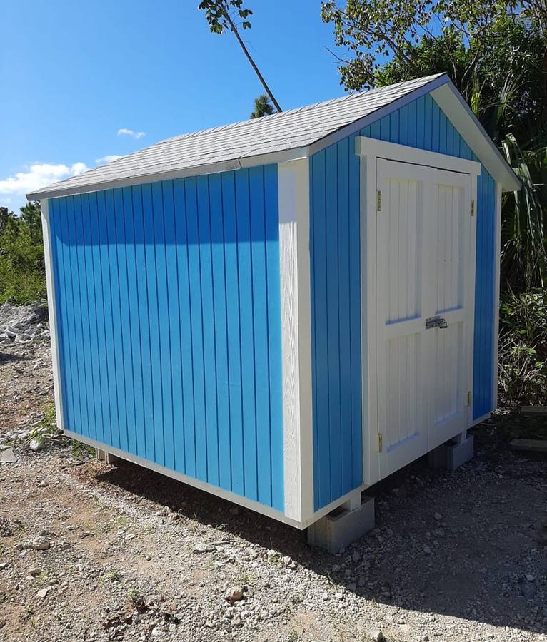 Custom shed painted blue with a contrasting shingle roof, finished install