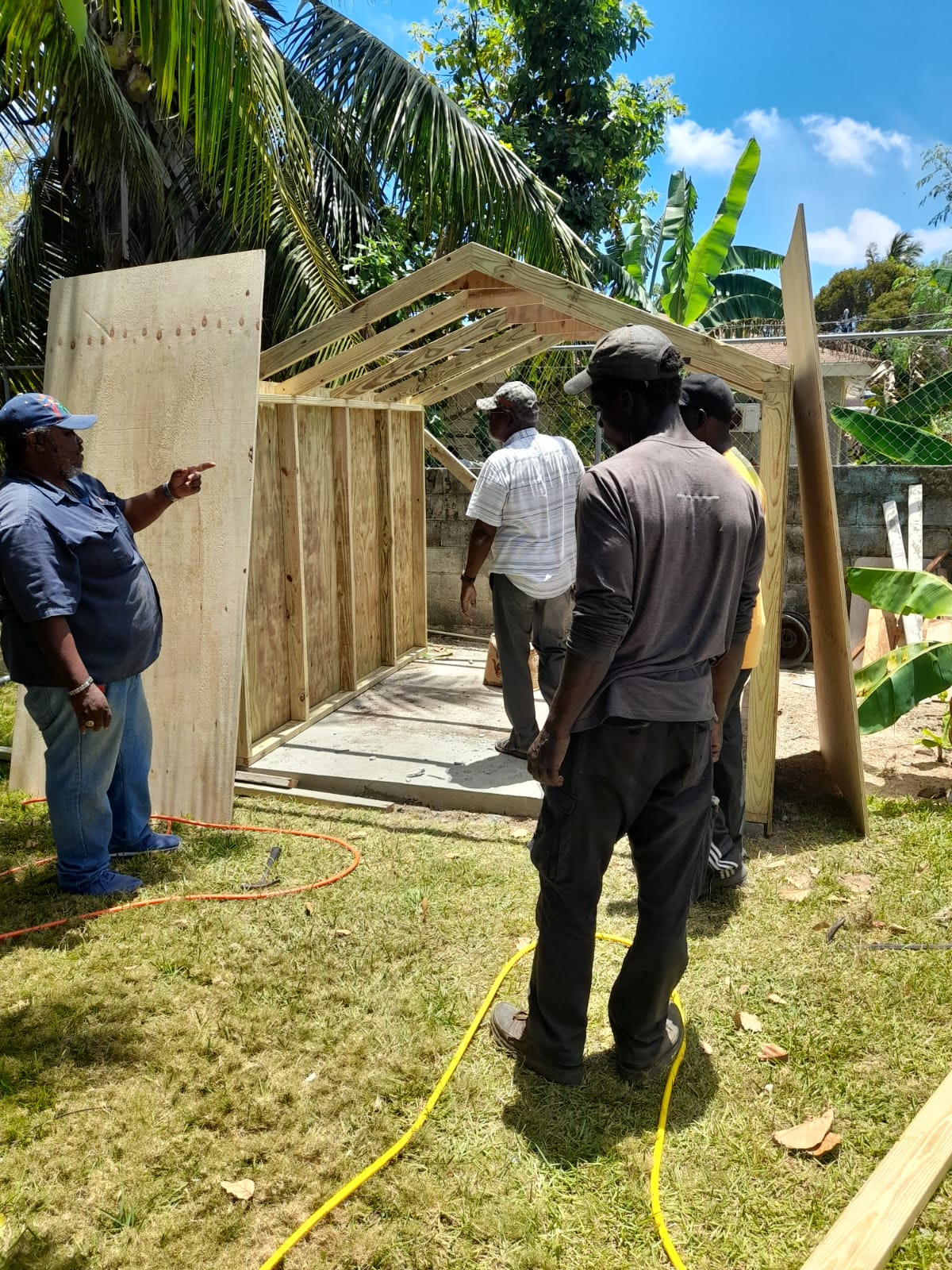 Same shed at the framing stage, crew working on the partially walled structure